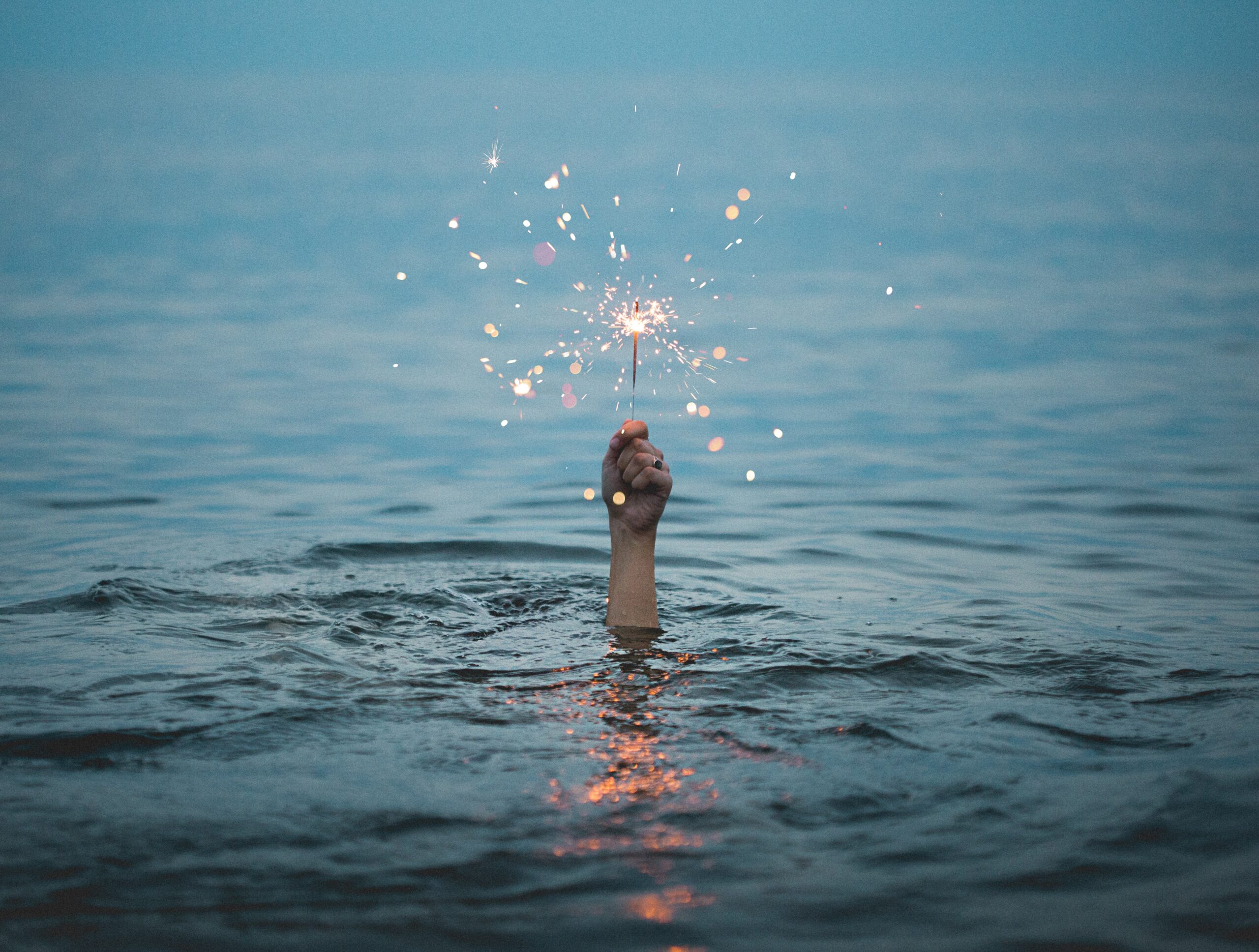 水面と腕と花火